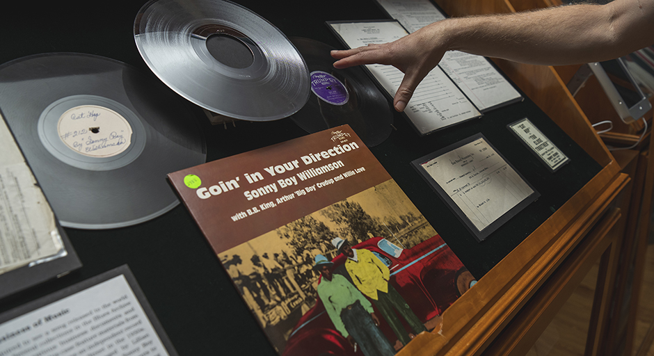 A display case holds vinyl records, album cover art and business records.