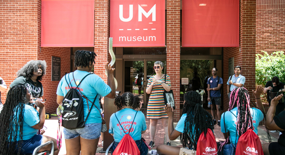 Student participants receiving a tour of the University Museum.