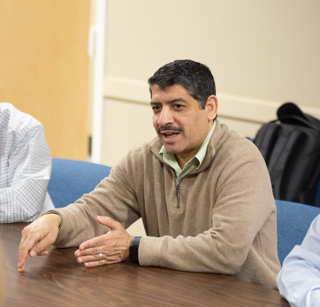 Researcher speaking to group at table