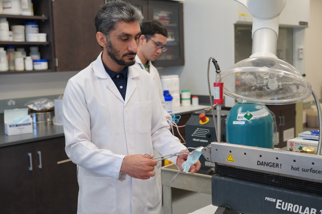 Researcher using a hot-melt extrusion machine