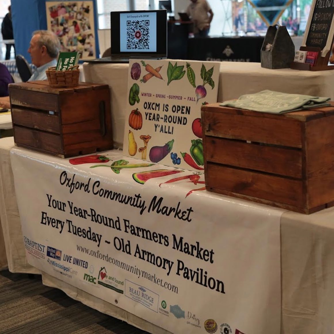 table set up with posters and advertisements for the Oxford Community Market