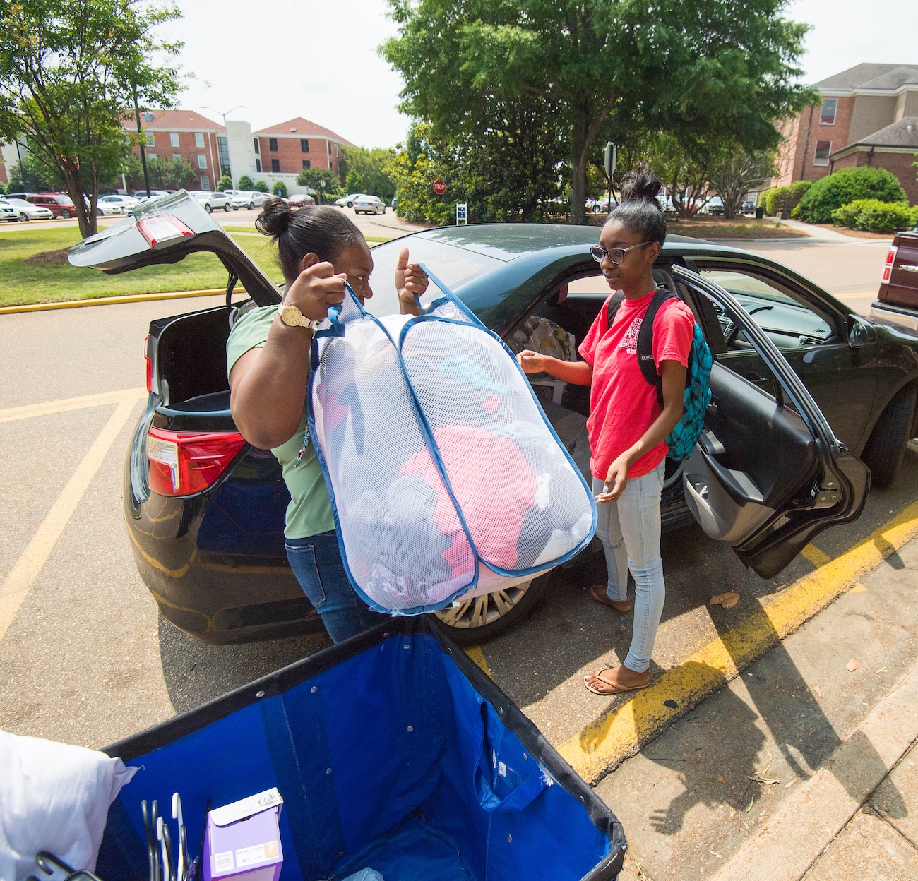 Students and their family load a vehicle