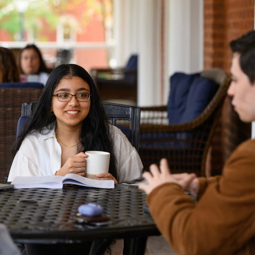 Croft student sitting on porch with another Croft student