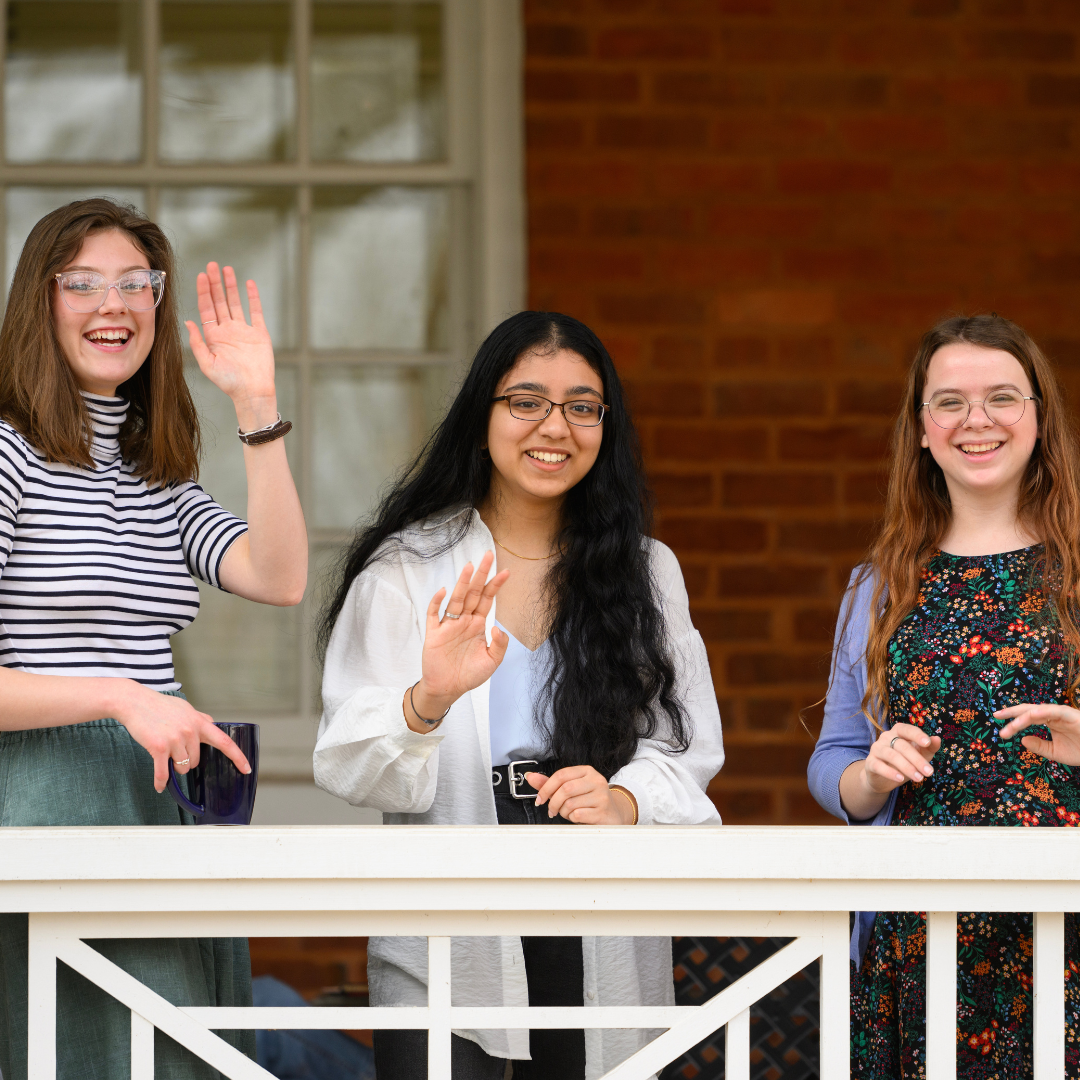 Students wave from porch