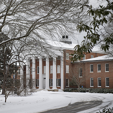 The lyceum covered in snow with the road barely cleared of snow