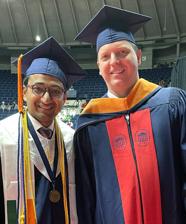 international male student and professor smile at graduation