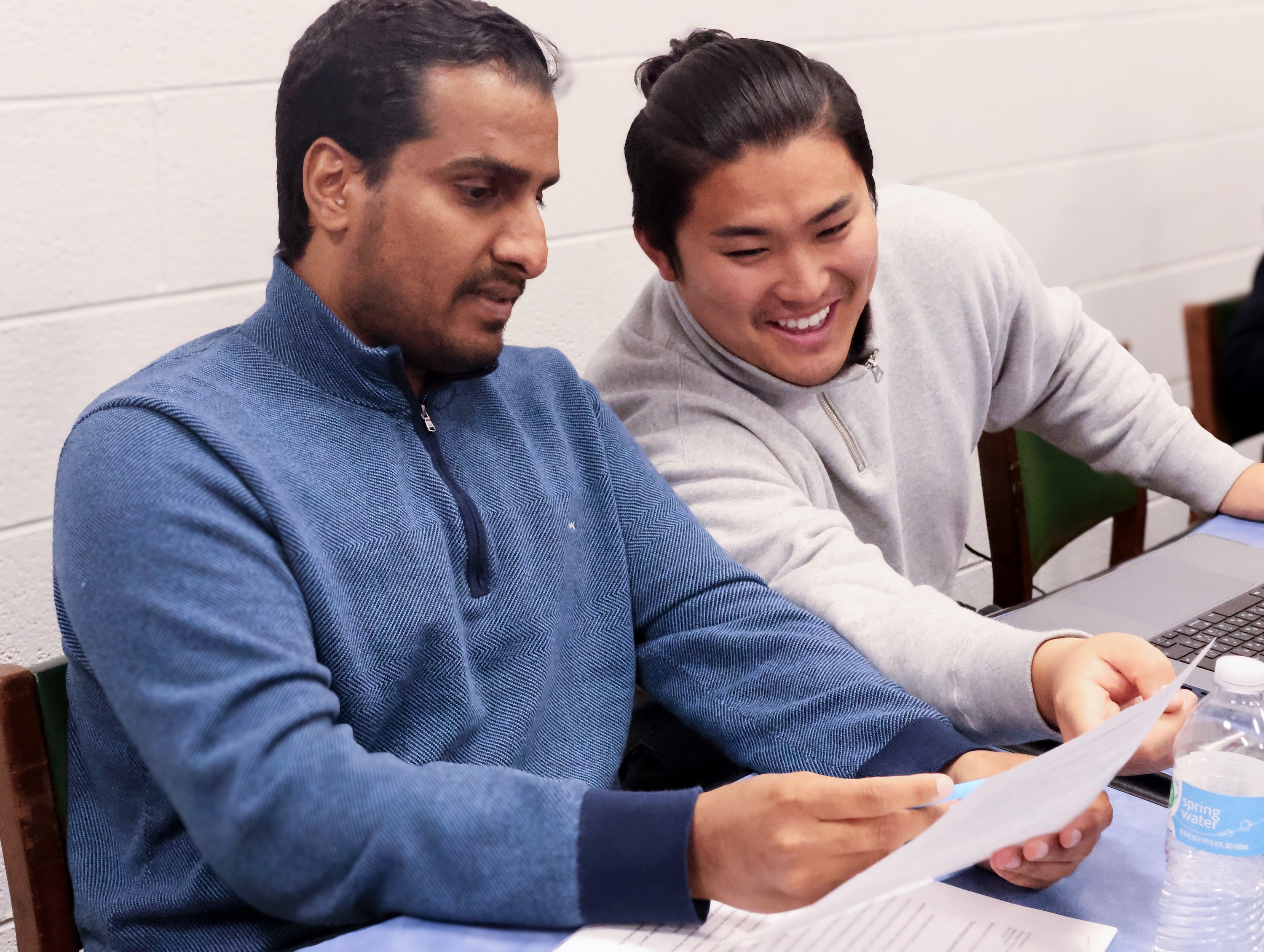 Two IEP students review material during a class.