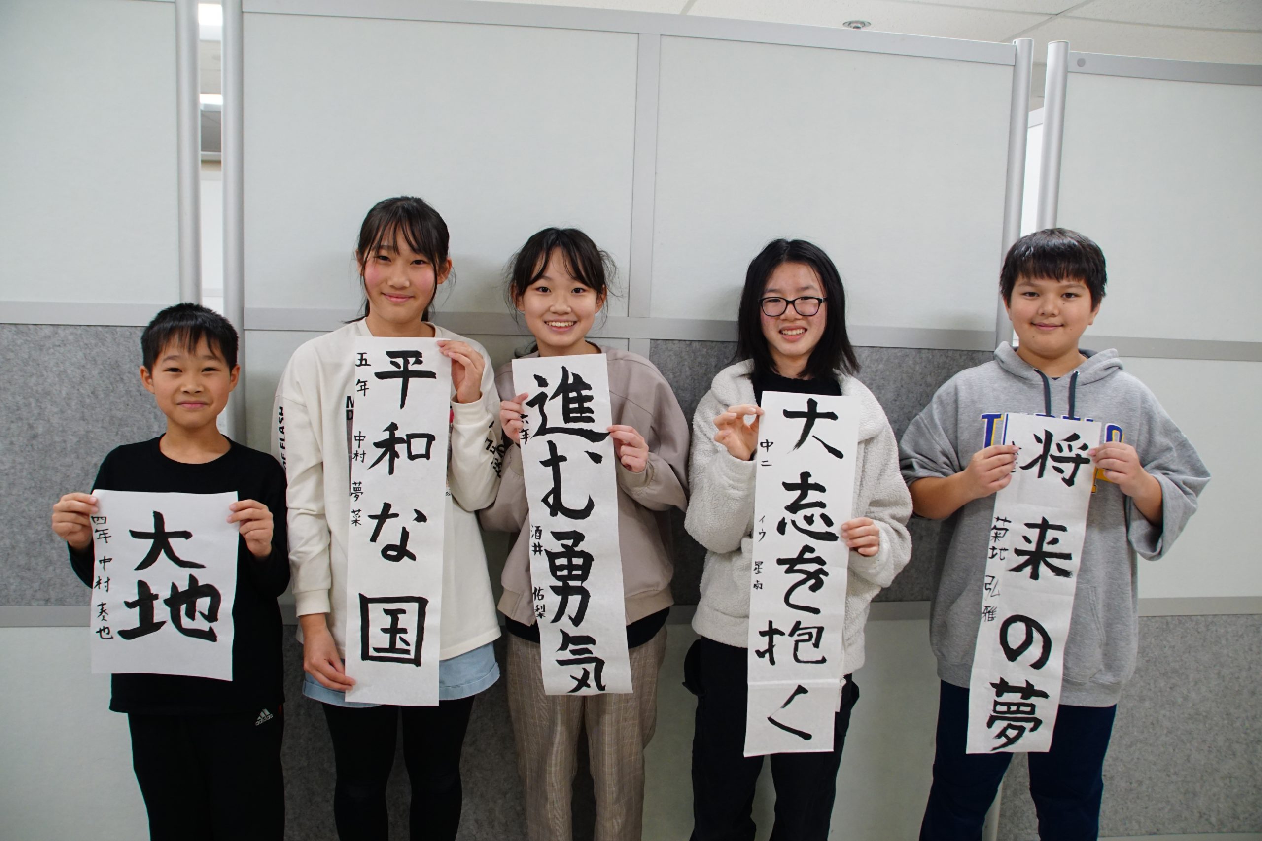 Japanese students posed with their own artwork featuring Japanese characters.