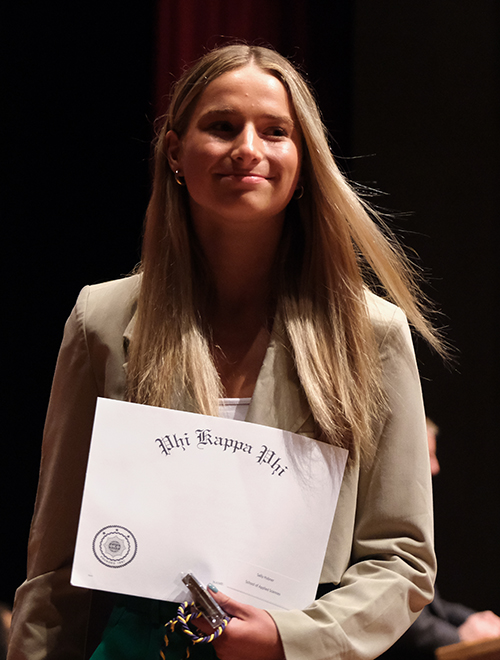 woman carrying a phi kappa phi award