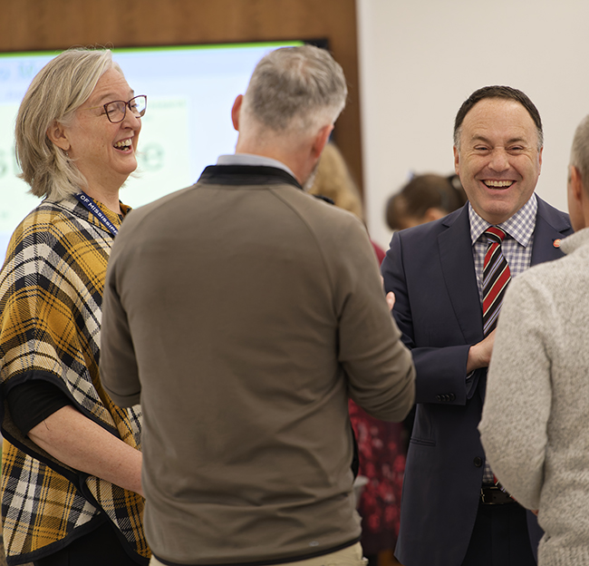 Faculty and staff talk and laugh together during a campus STEM event.