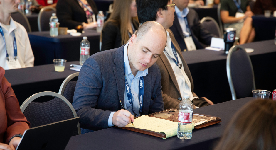 A man takes notes during a presentation.