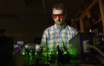 Photo of researcher with laser multi-beam technology.