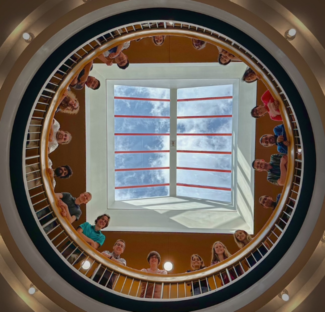 A group of students looking down from a balcony.