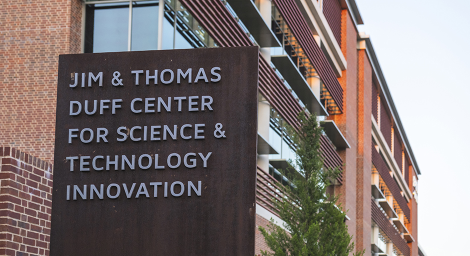 A sign outside a large brick building reads 'Jim and Thomas Duff Center for Science and Technology Innovation.'