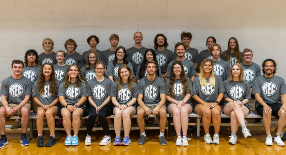 Outdoors student employees sitting on bleachers.