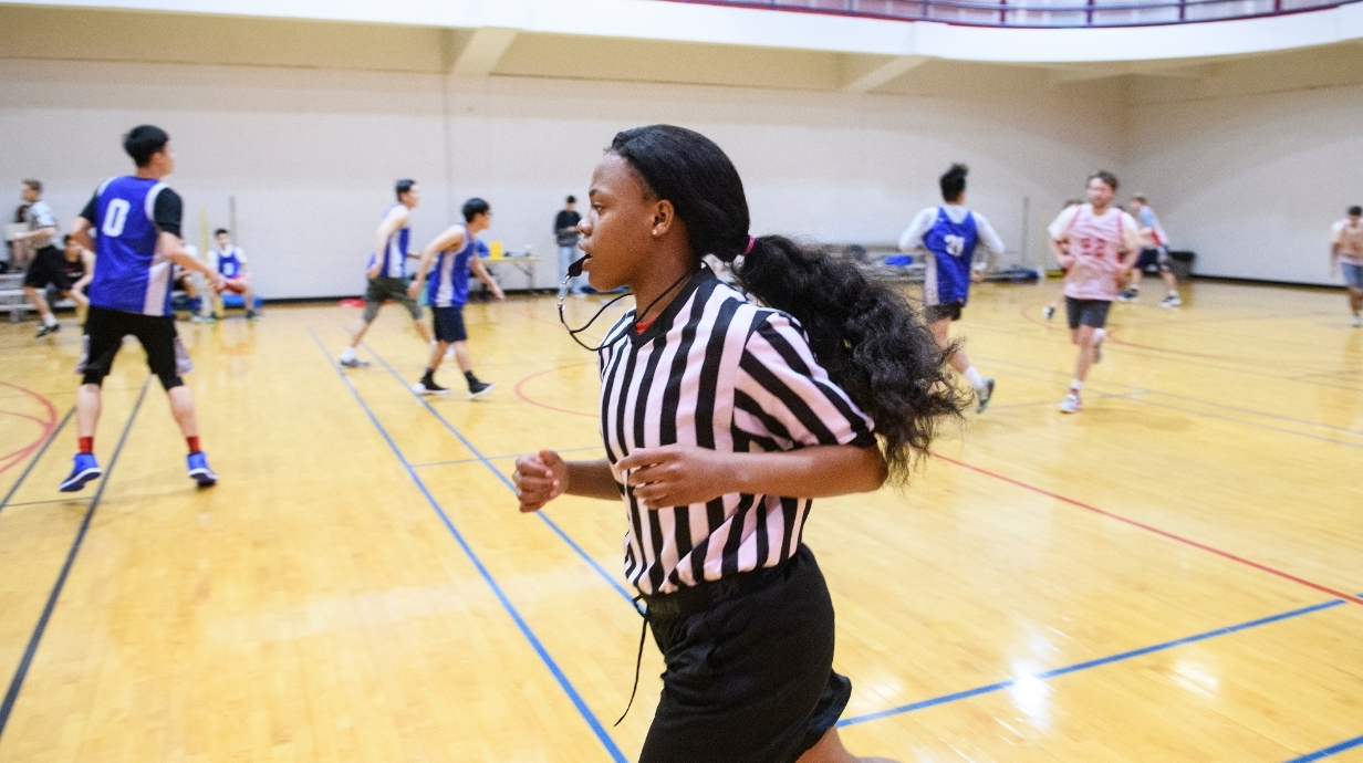 Student employee officiating an Intramural basketball game.