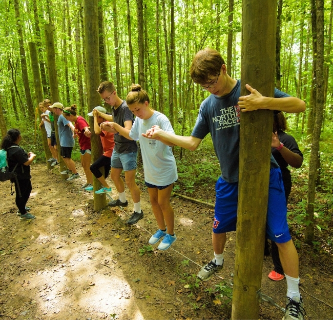 Group working together in a team building exercise at the challenge course.
