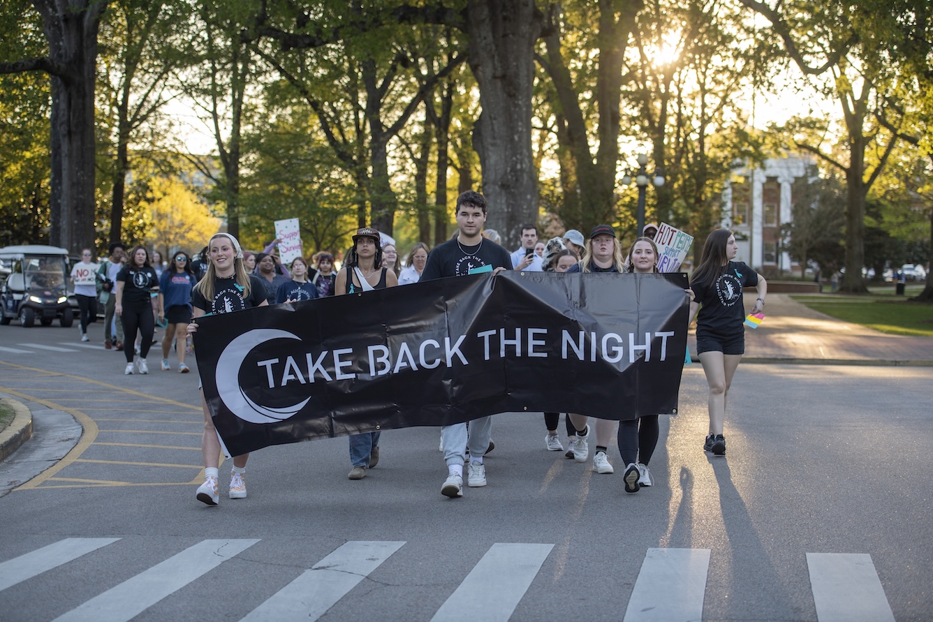 Take Back the Night participants hold a banner.