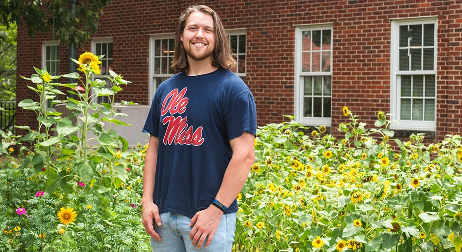 Portrait of Houston Griffith in front of a wildflower garden in bloom.