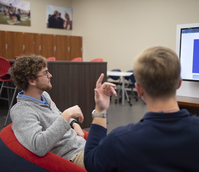 Two men look at a presentation on a screen at the FSL office