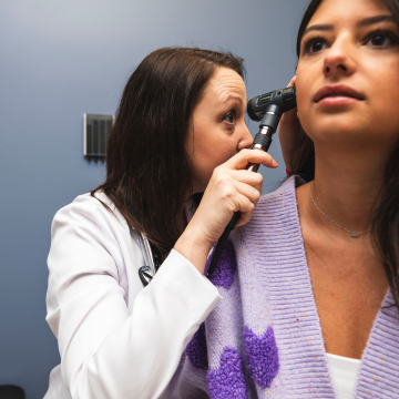 Provider examines patient's ear.