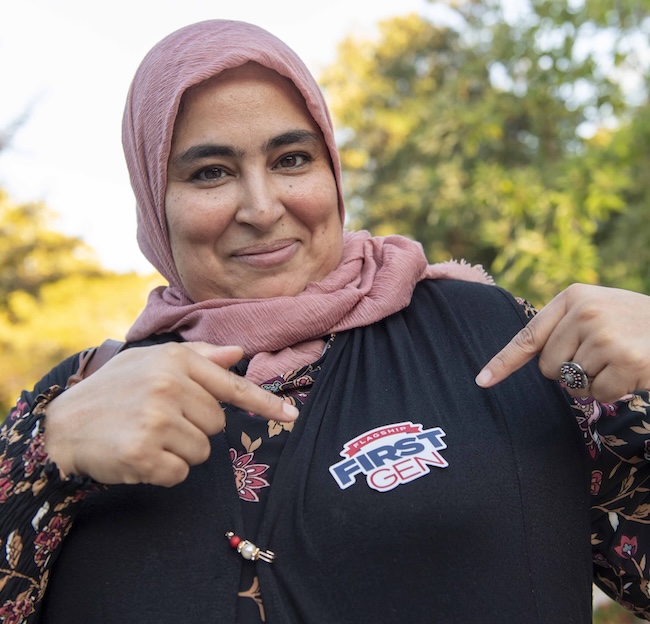 A woman proudly points to her Flagship First Gen sticker. 