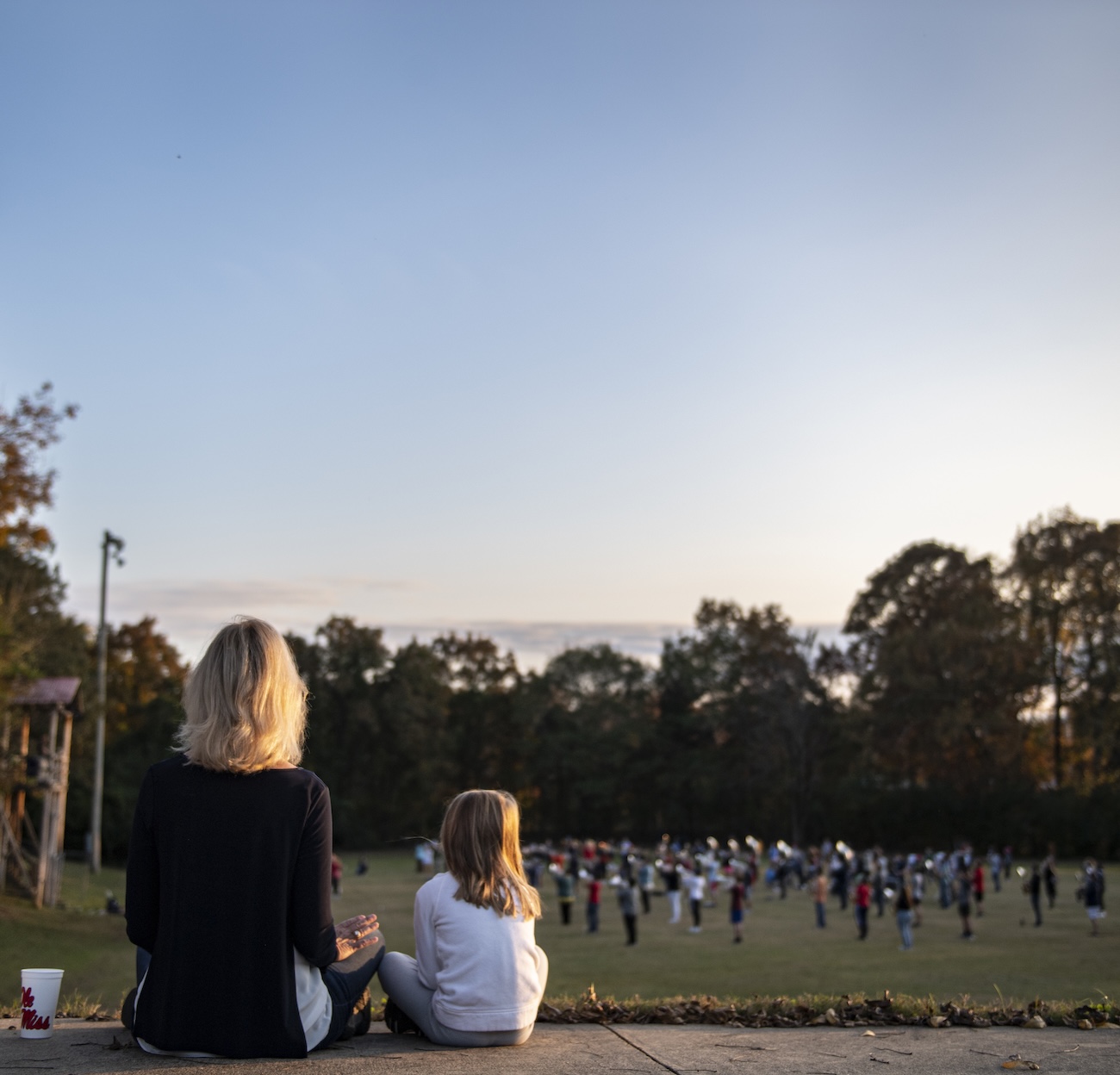A grandmother and granddaughter listen to the Pride of the South practice.
