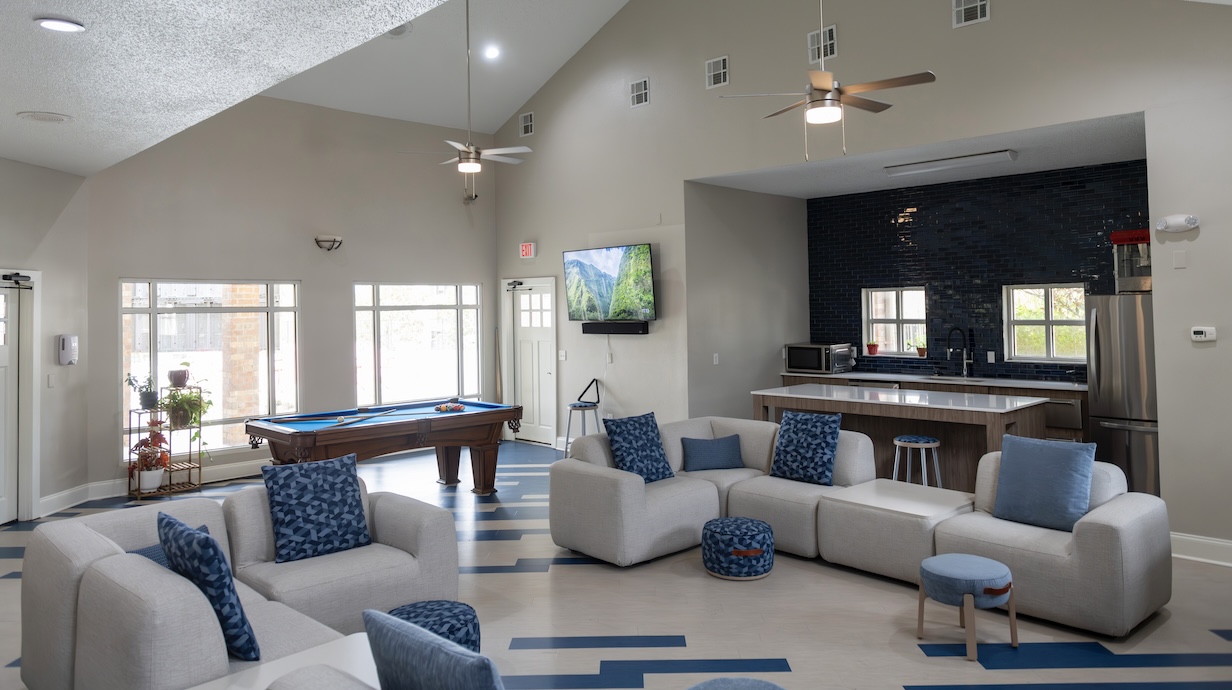 Couches and chair sitting in front of a kitchen area