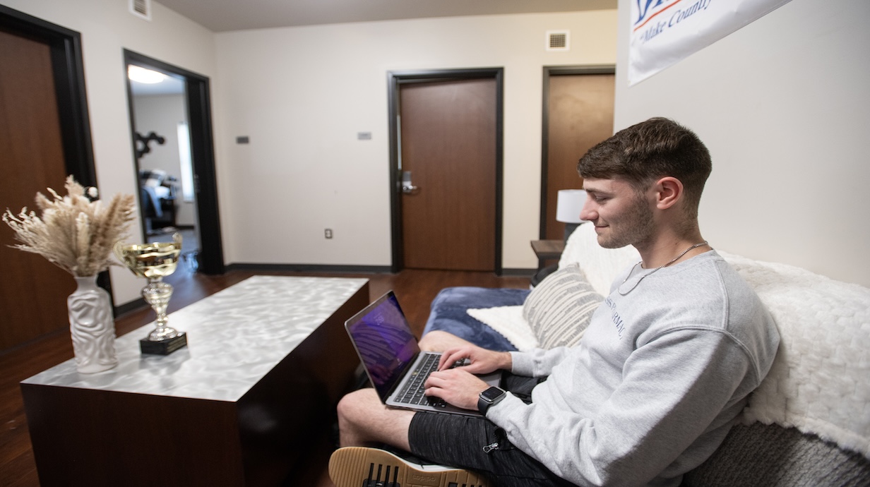 Student sitting on couch with laptop 