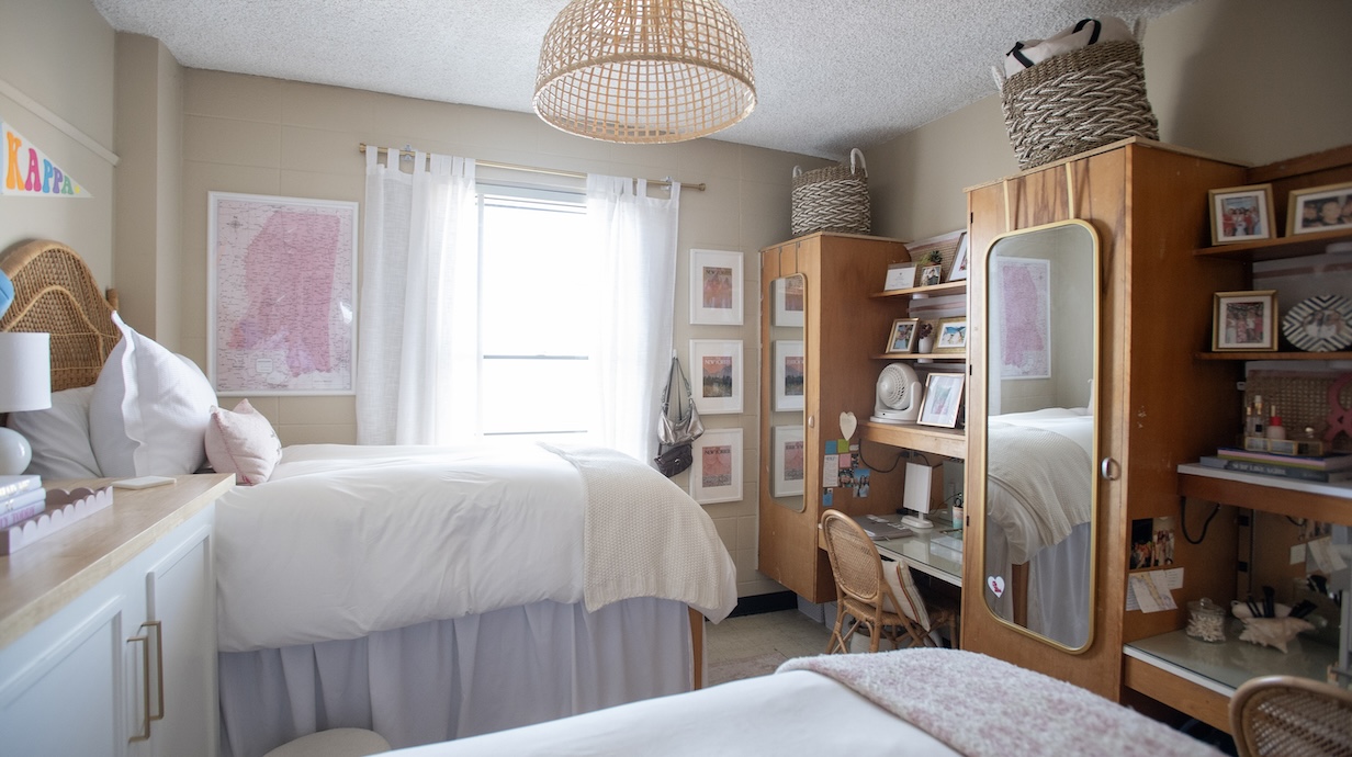 Photo of beds and window in front of two desks.