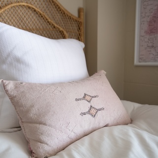 White and Pink pillows sitting on a bed