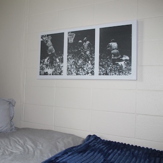 three photos on the wall above a bed