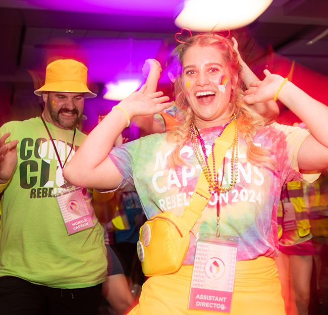 Two students dancing in a colorful area