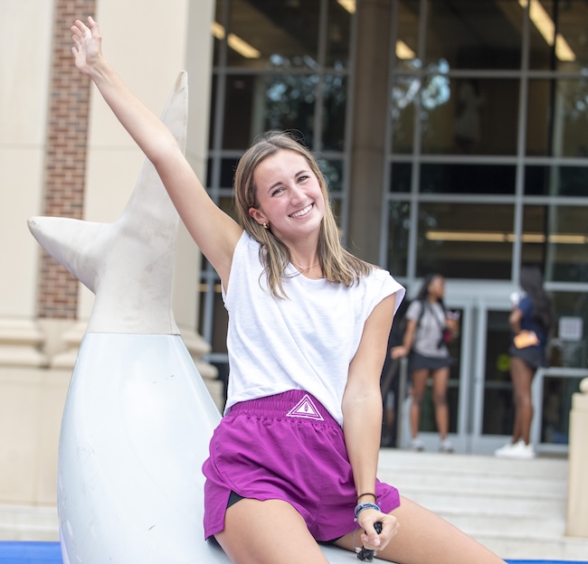A student rides the mechanical shark on the Union plaza.
