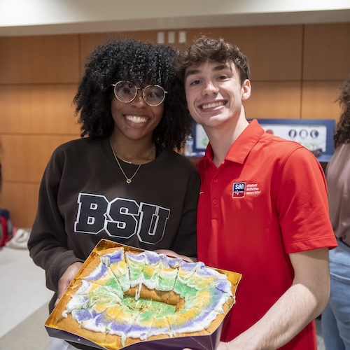 Students pose with a king cake.