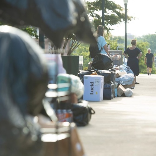 Move-in boxes on the sidewalk with people nearby