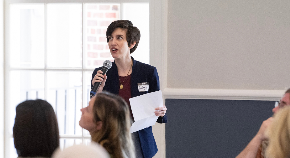 Emily Donahoe speaking into a mic at a CETL event with attendees in the foreground