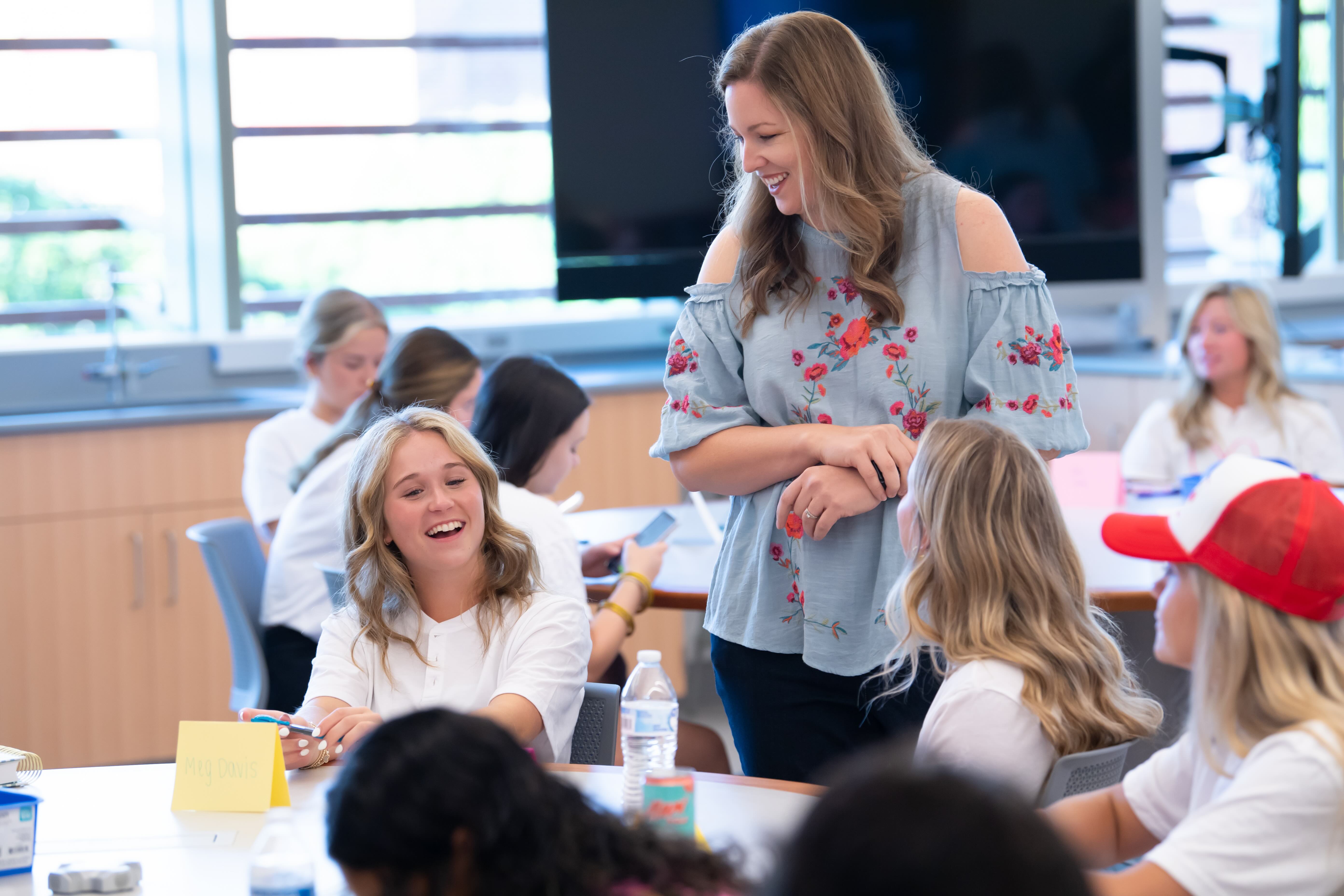 An instructor works with students in an active learning classroom