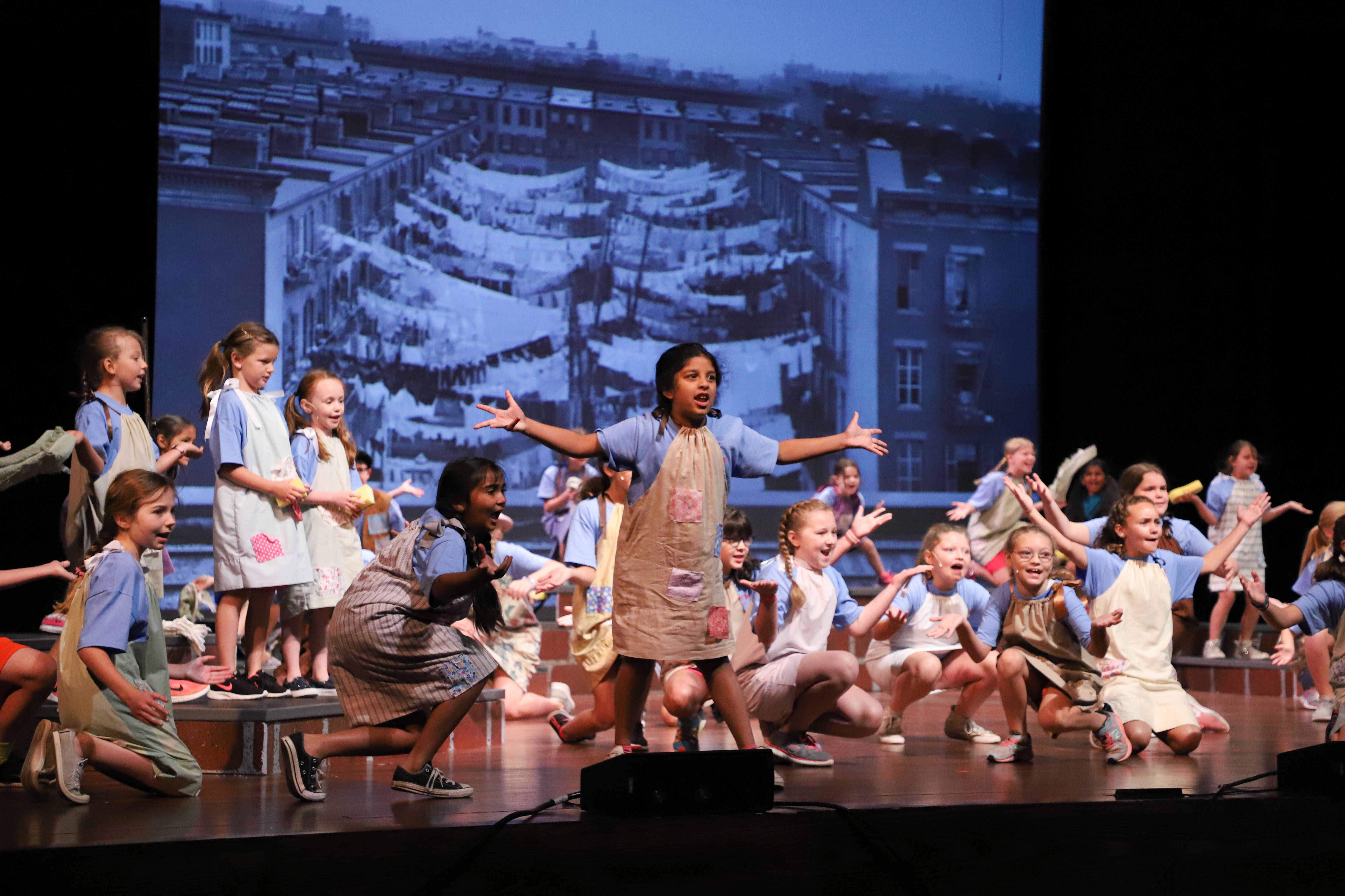 A group of children on stage dressed as Orphans for a performance