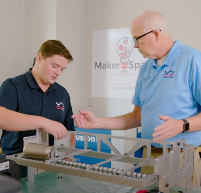 A instructor works with a student in the CME Maker Space.
