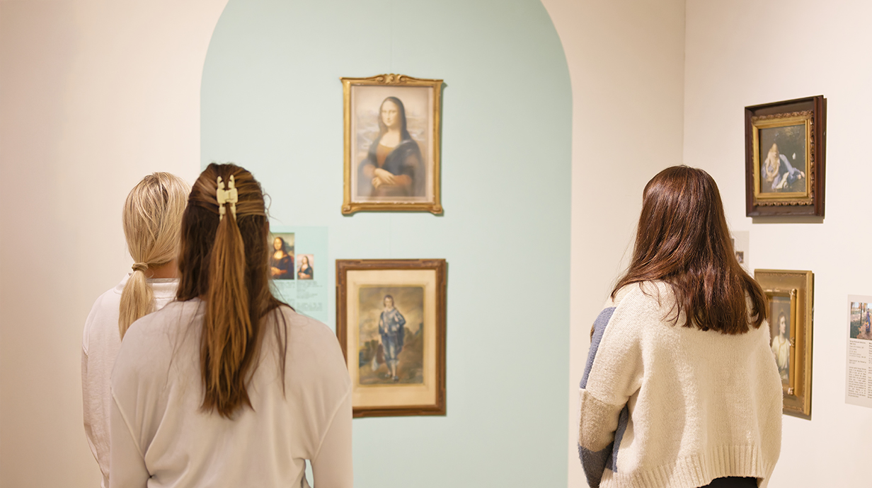 3 visitors view framed paintings displayed in the Mary Buie and Kate Skipwith Collection gallery, standing in front of a softly colored wall featuring historic portrait and decorative artworks.
