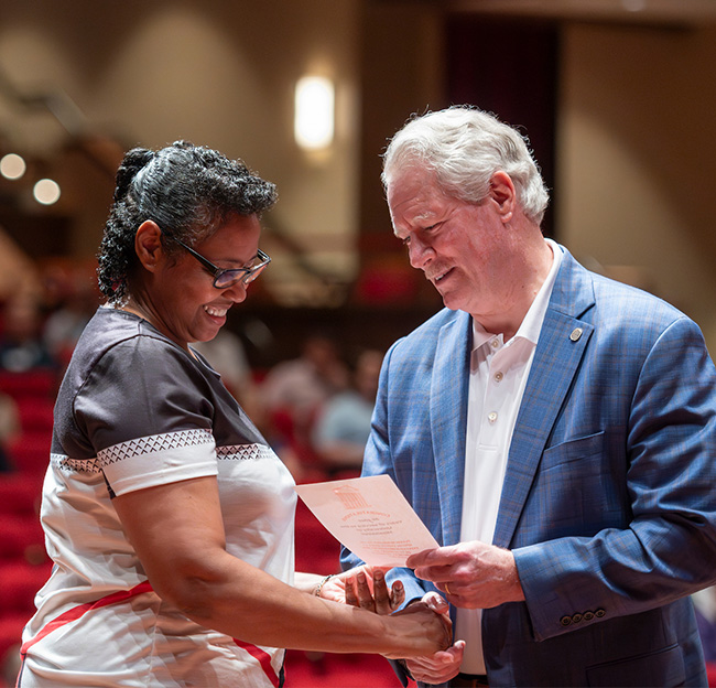 chancellor hands flyer to staff person