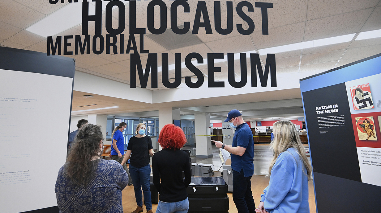 A group of people examines a museum display.