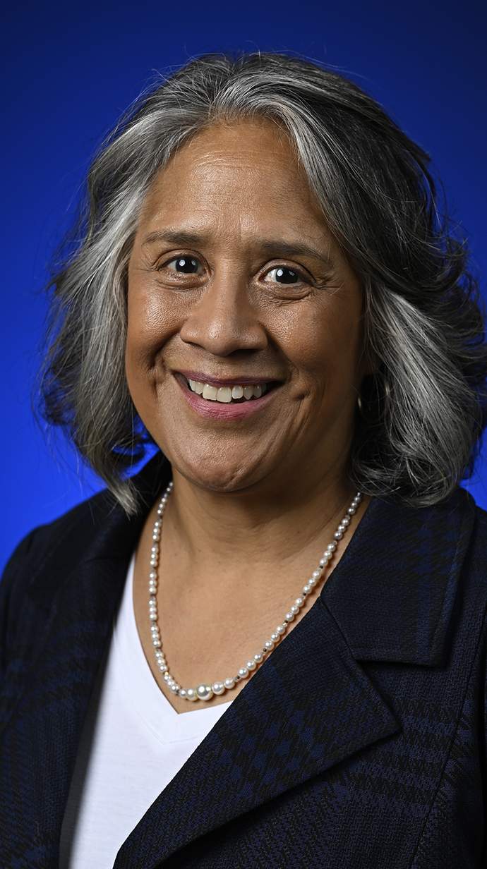 Headshot of a woman wearing a black jacket over a white blouse.