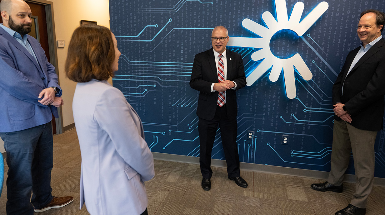 C Spire executives Graham Miller (left) and Hu Meena (right) gather with journalism Dean Andrea Hickerson and Provost Noel Wilkin at C Spire's new space at Insight Park. 