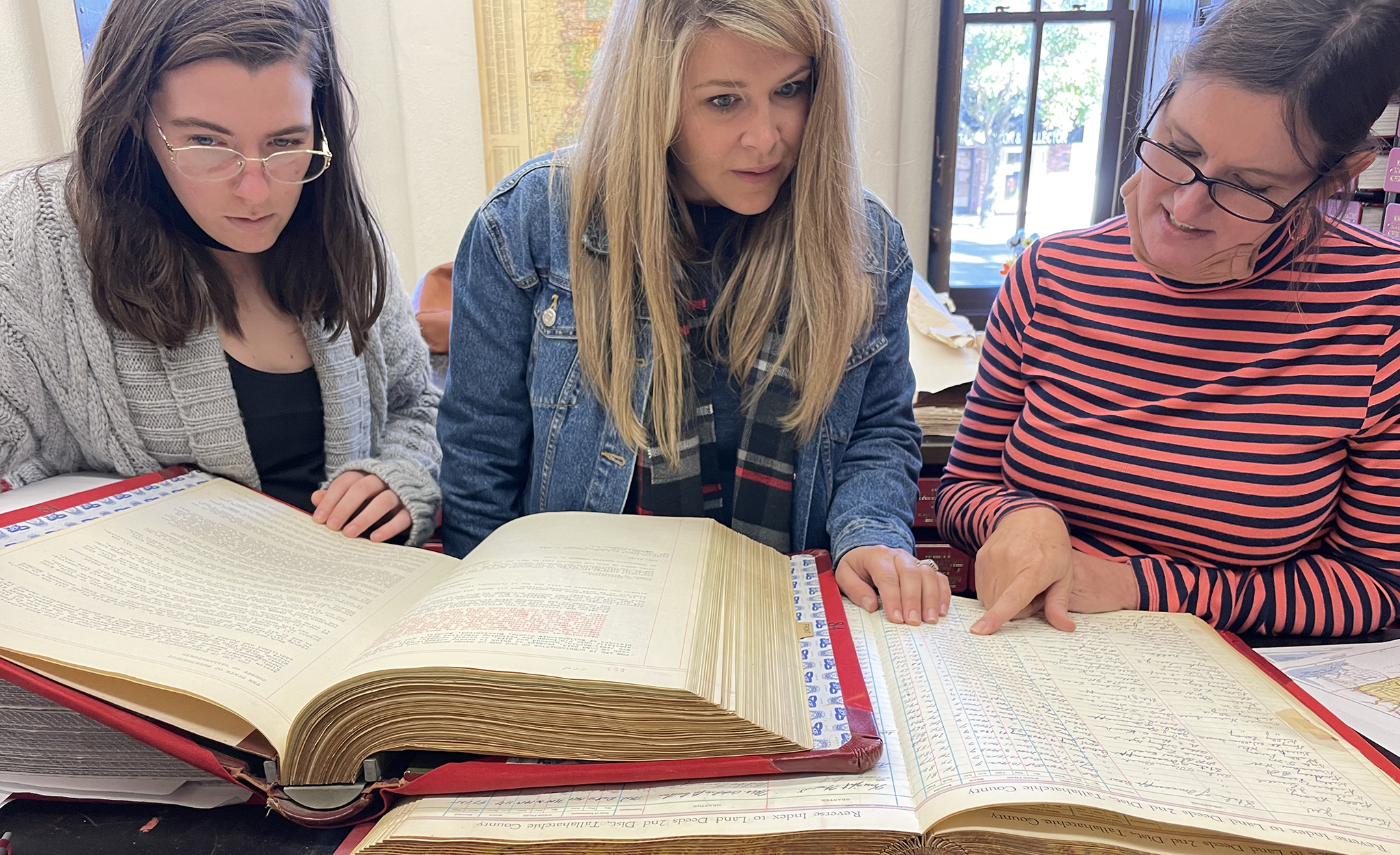 Professor and students look through a book together. 