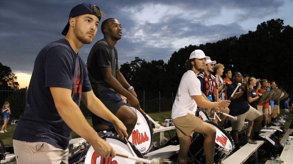 A drum line practices outdoors.