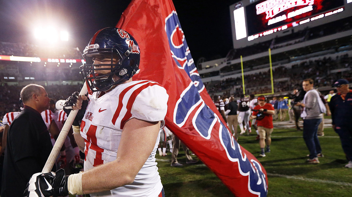 Football player carrying an Ole Miss school flag