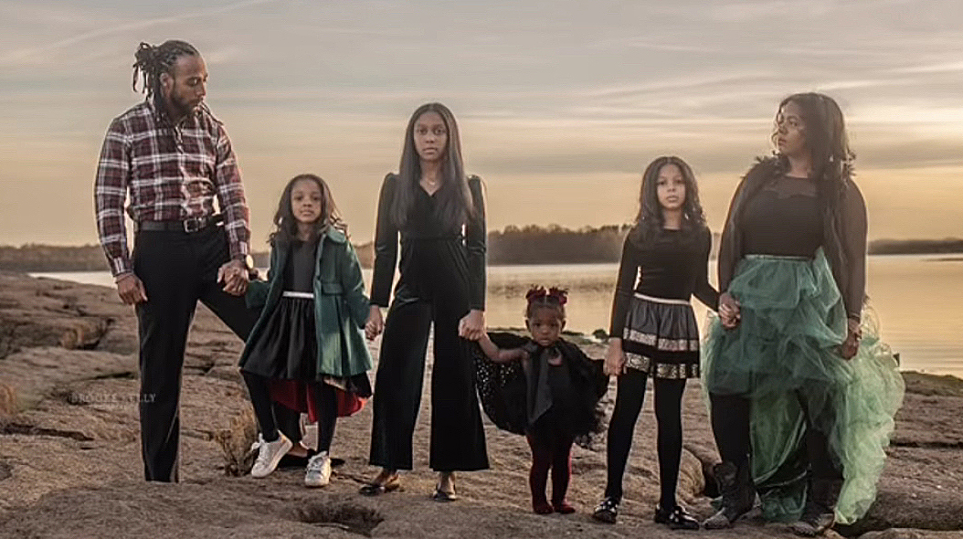 Dexter McCluster and his five daughters stand on a beach.