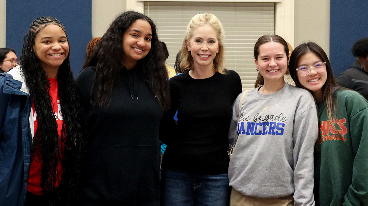 University alumna Renvy Pittman stands with four Ole Miss students.